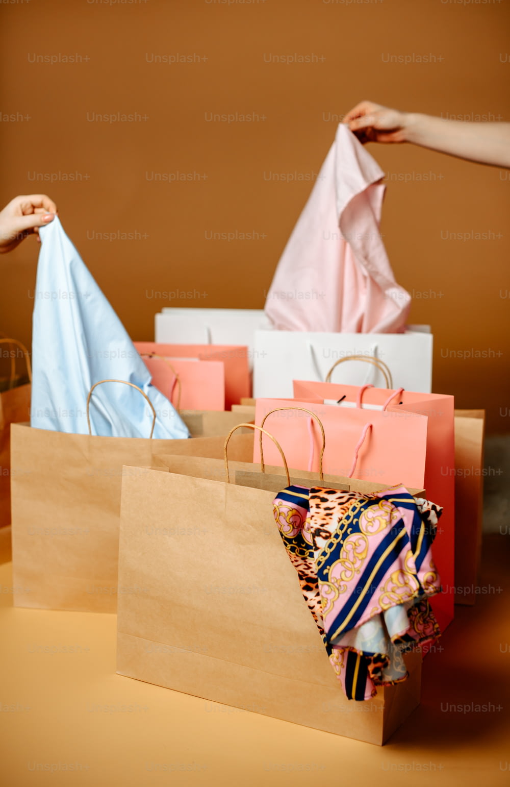 a person holding a paper bag over a pile of bags