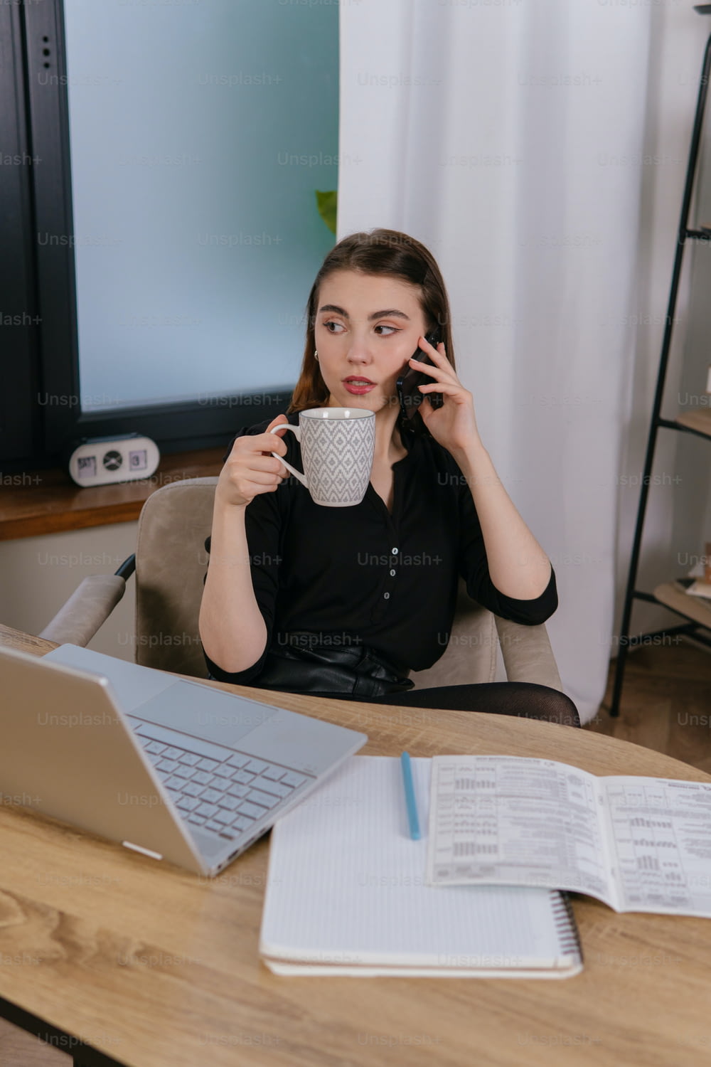 Une femme assise à une table avec un ordinateur portable et une tasse de café