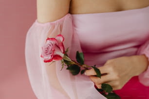 バラを持つピンクのドレスを着た女性