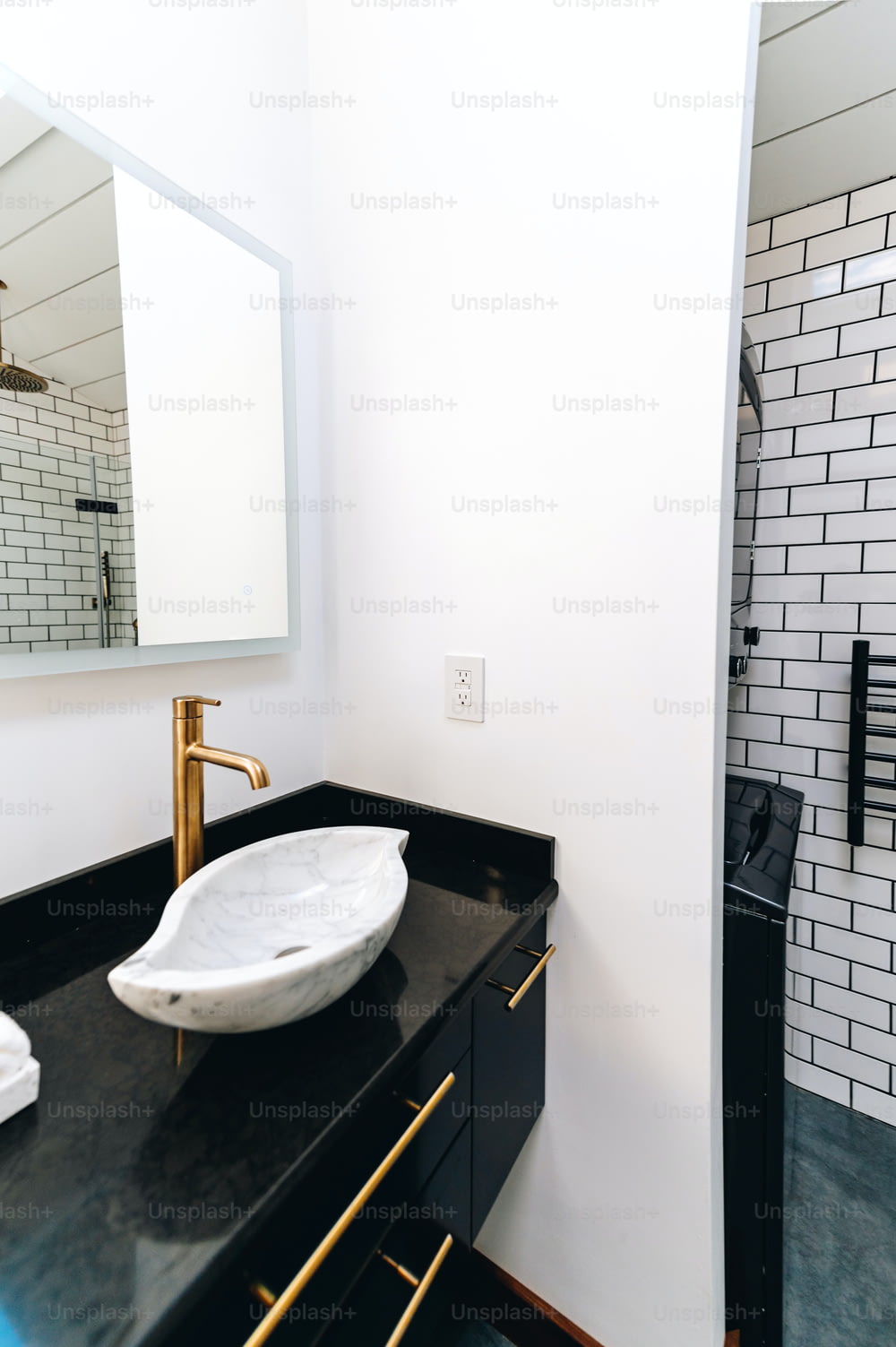 une salle de bain avec un comptoir noir et un lavabo blanc