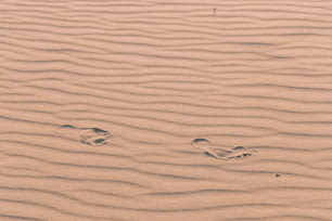 two footprints in the sand of a beach