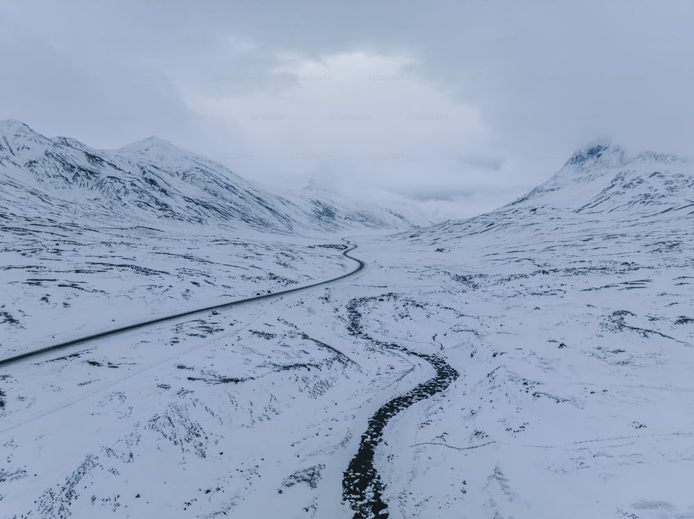 a snowy mountain with a winding road in the middle