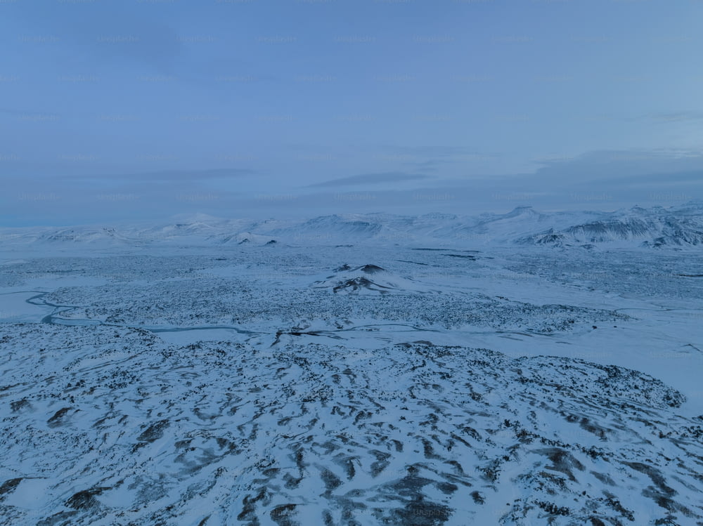 a snowy landscape with mountains in the distance