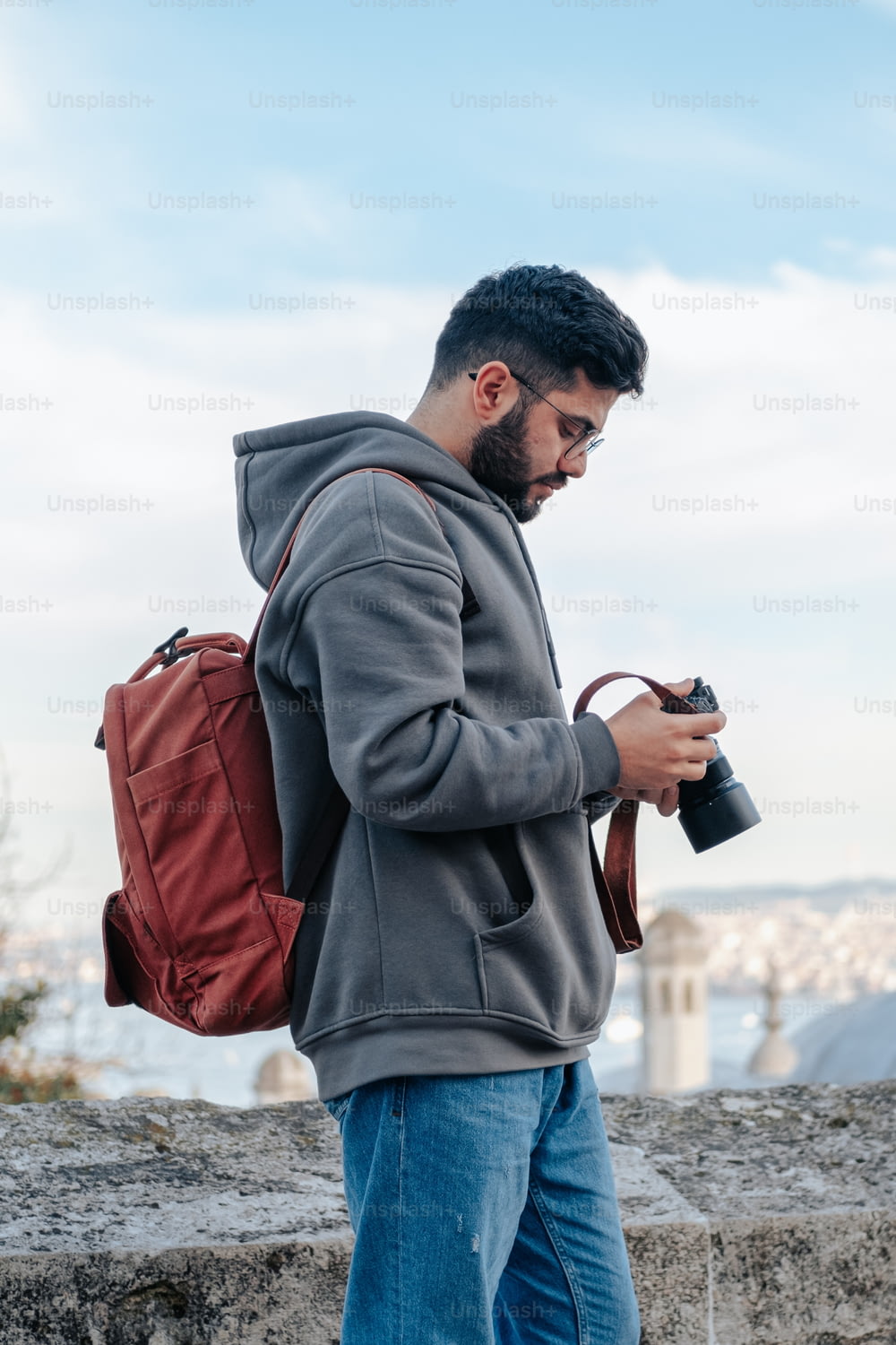 um homem com uma mochila olhando para seu celular