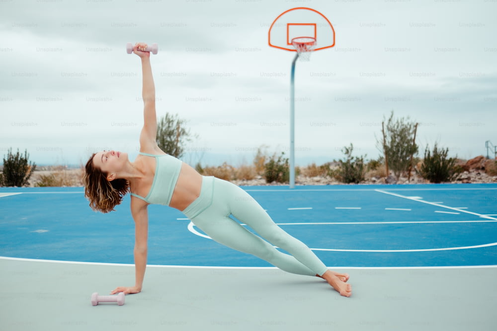 a woman doing a handstand on a basketball court