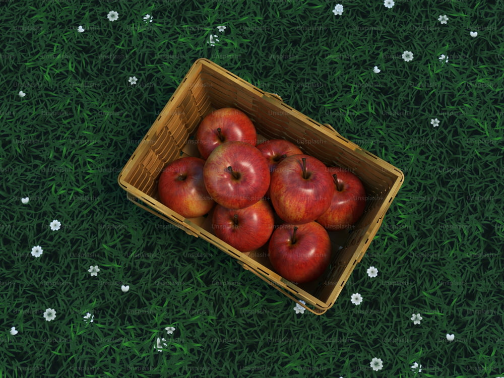 a wooden box filled with red apples on top of a green field