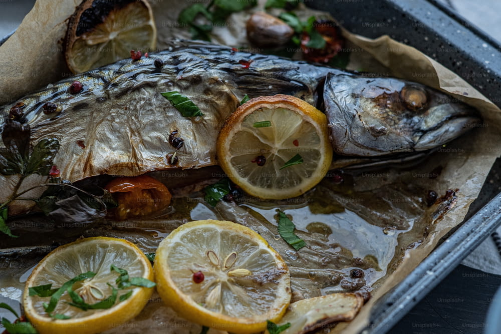 a pan filled with fish and lemon slices