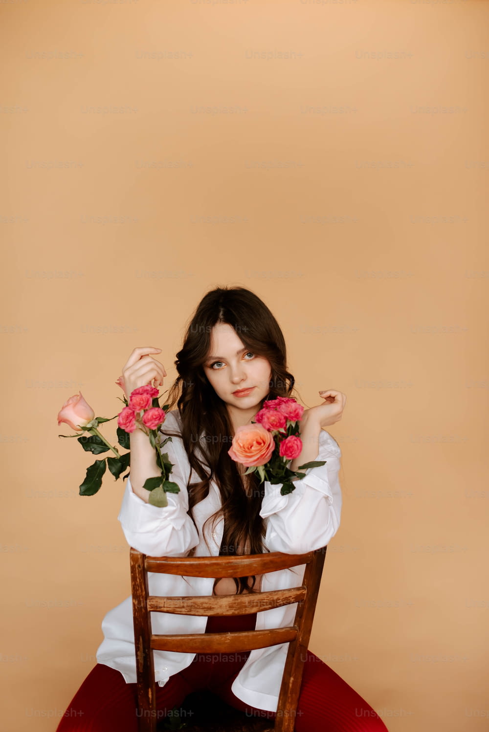 a woman sitting on a chair holding roses