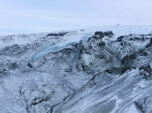 遠くに氷河がある雪に覆われた山
