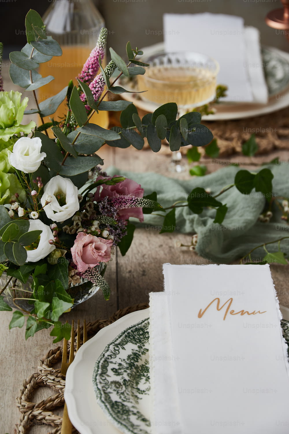 a place setting with a menu and flowers
