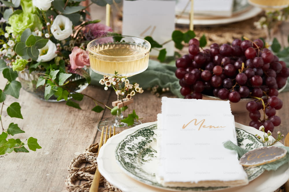 a place setting with place cards and a glass of wine