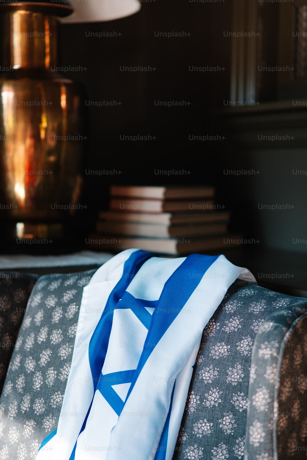 a blue and white scarf sitting on top of a couch