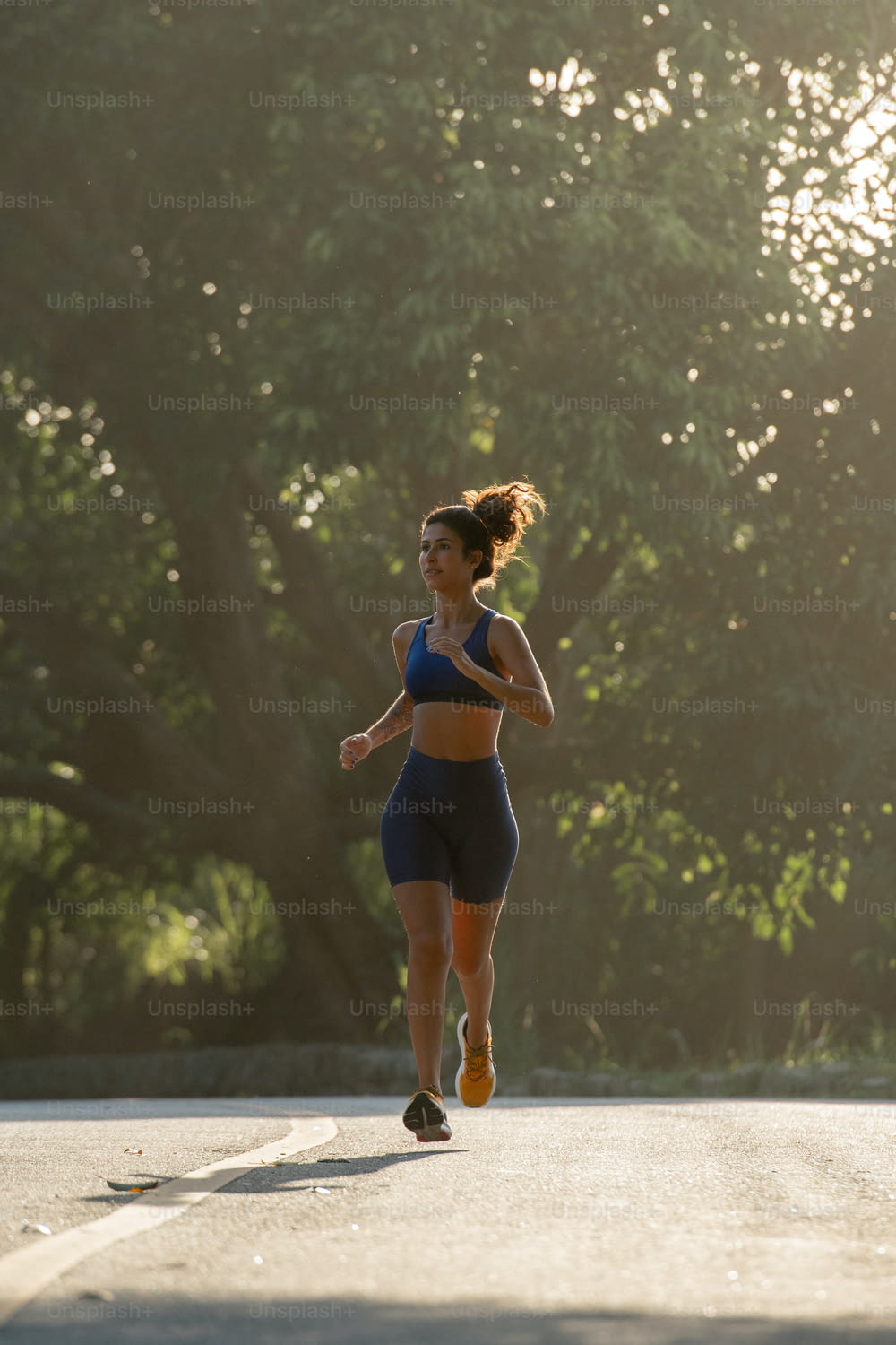 a woman running down a street in a blue sports bra top