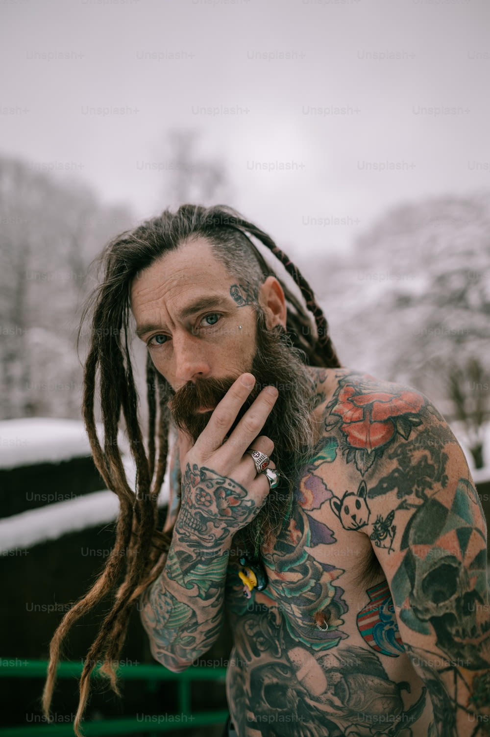 Un uomo con lunghi dreadlocks e tatuaggi sul viso