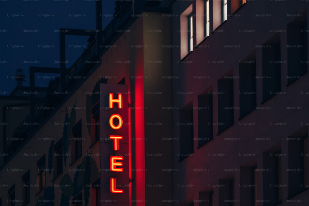 a hotel sign lit up at night on a building