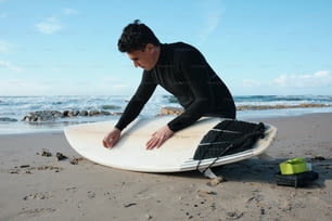 해변에서 서핑 보드에 앉아있는 남자