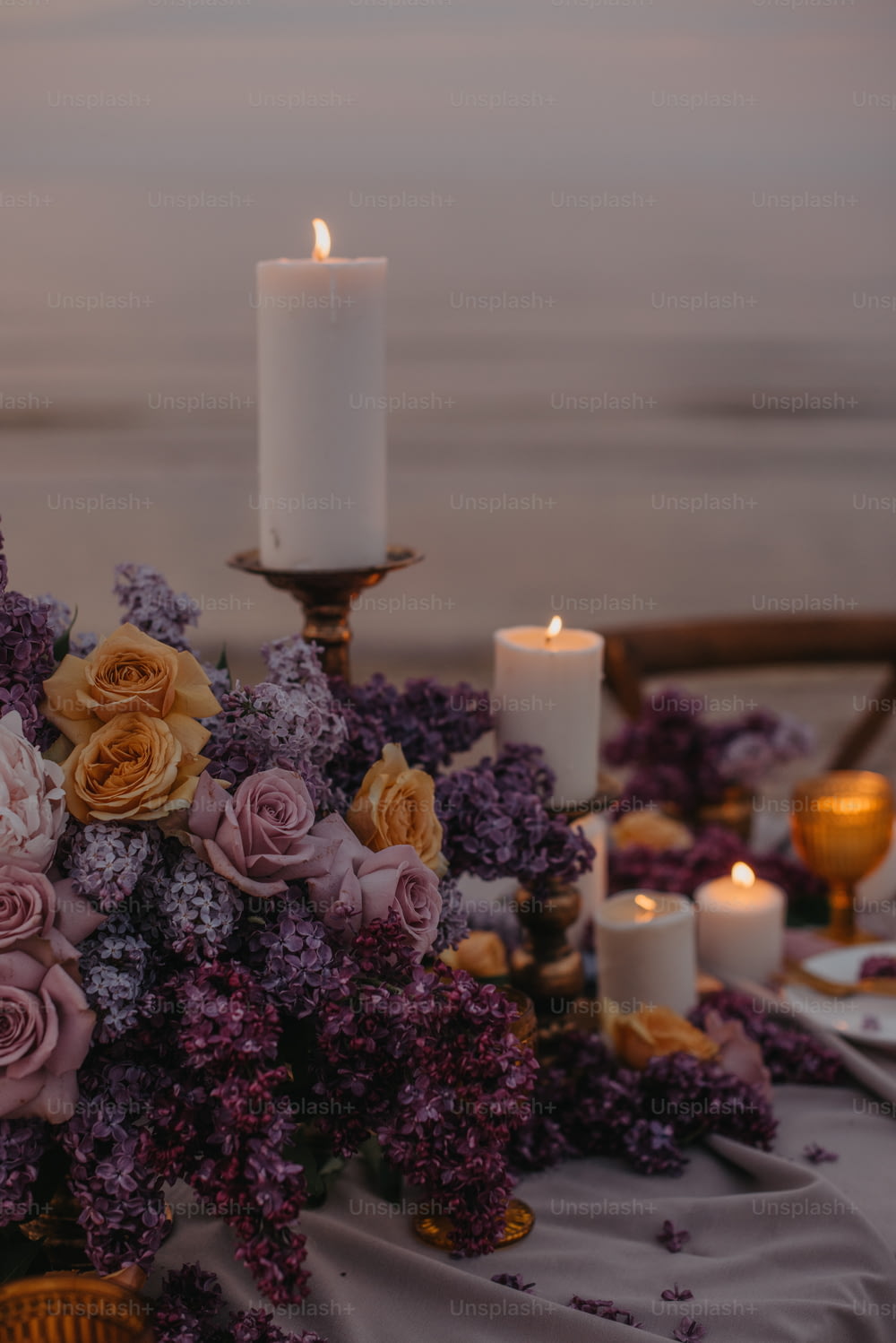 a table topped with a vase filled with flowers and candles