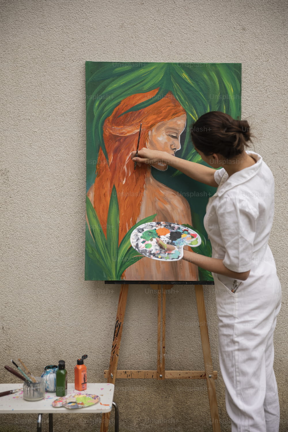 Una mujer está pintando un cuadro en un caballete