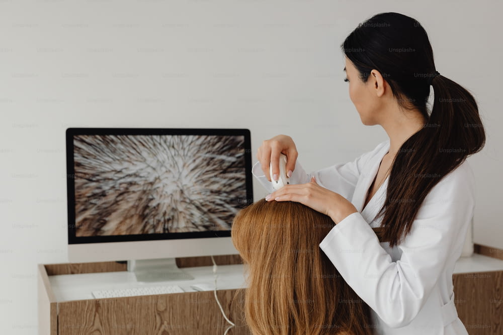 a woman is cutting another woman's hair in front of a computer
