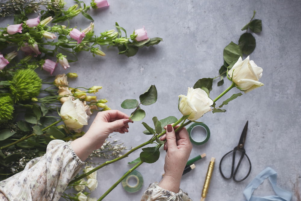 a woman is cutting flowers with scissors