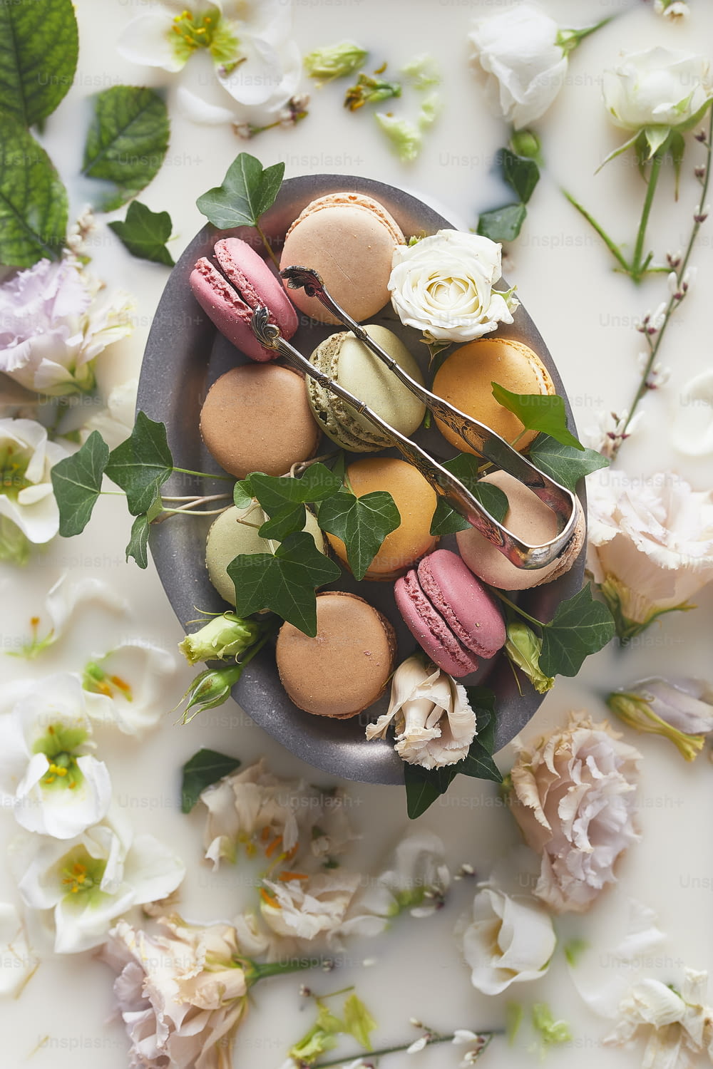 a bowl of macaroons and flowers on a table