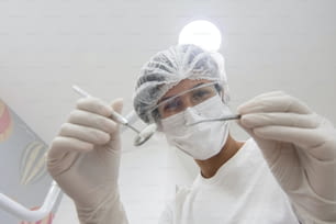 una persona con una máscara quirúrgica y sosteniendo un par de tijeras