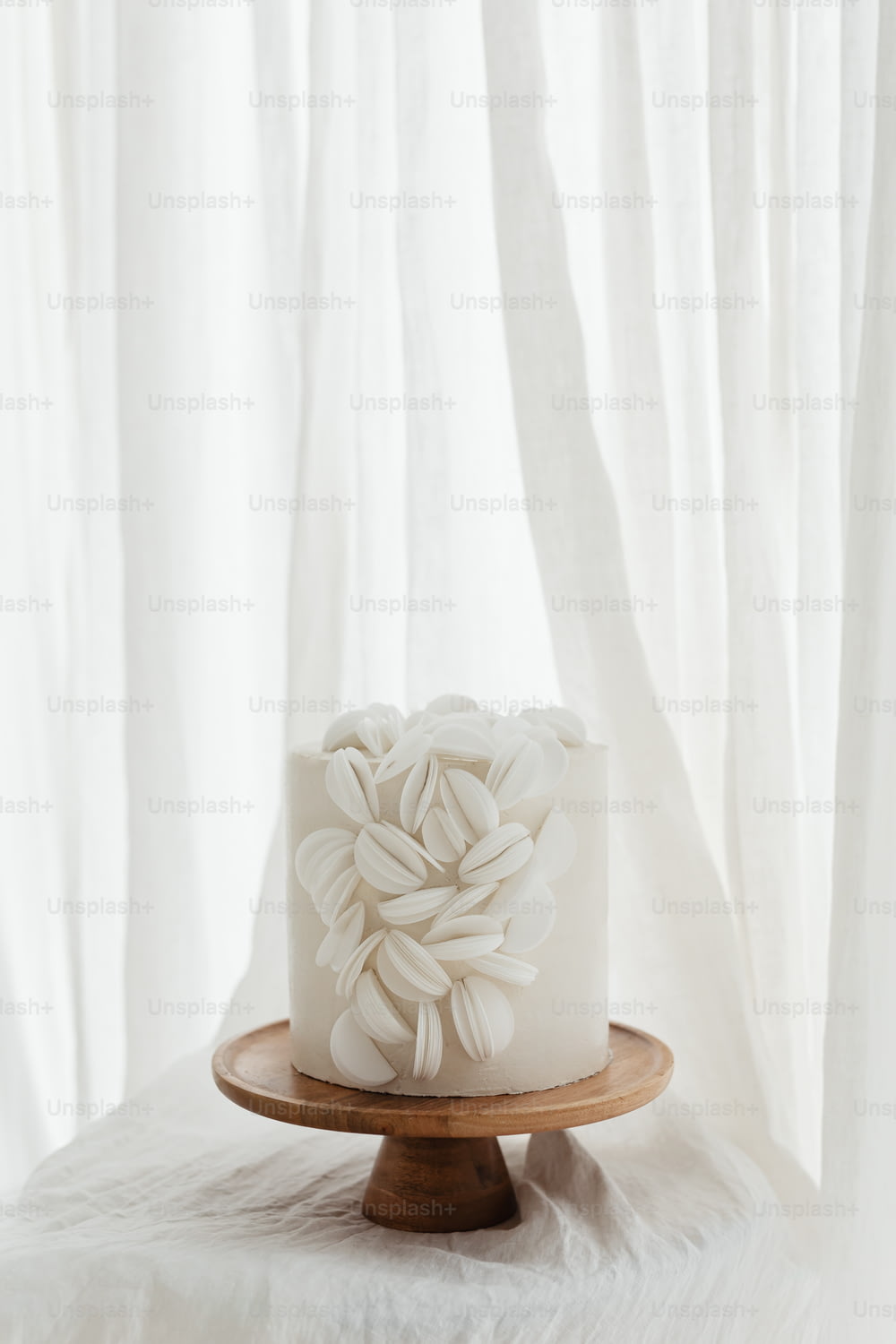 Ein weißer Kuchen sitzt auf einem Holzteller