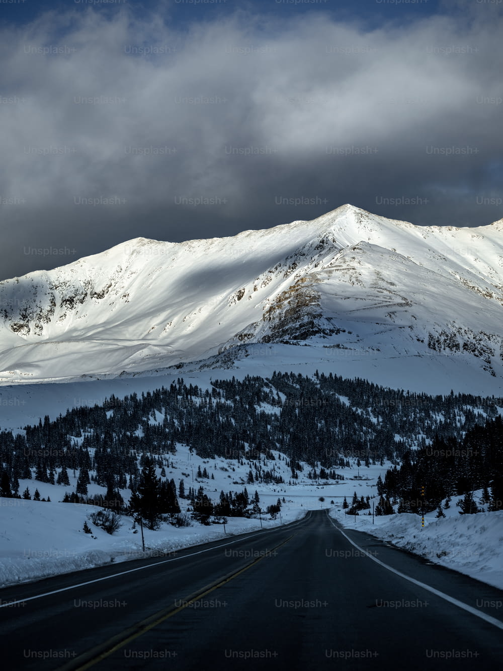 a snow covered mountain with a road in the foreground