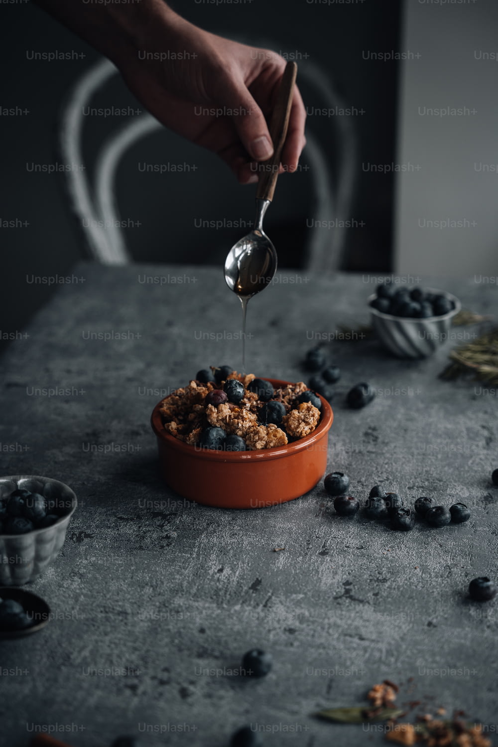 a person is spooning blueberries into a bowl