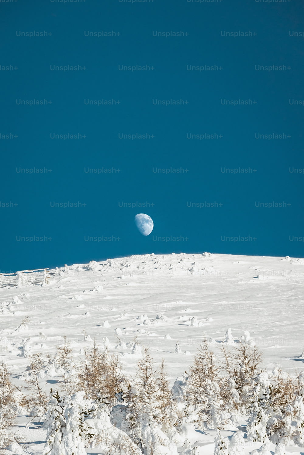 uma vista da lua do topo de uma colina nevada
