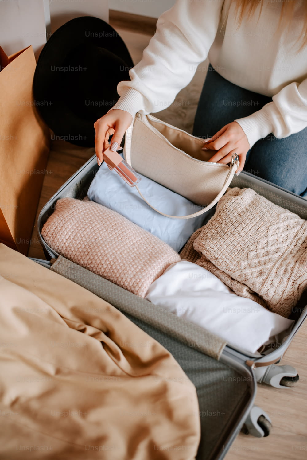 a woman opening a suitcase with clothes in it