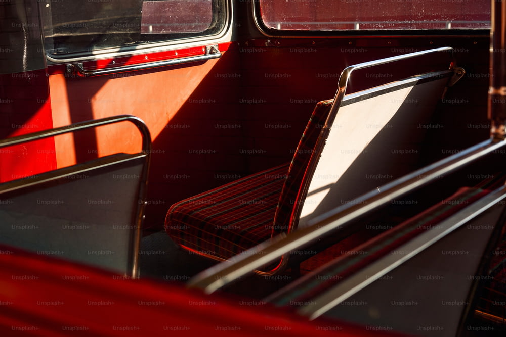 a red and black bus with two seats and a window