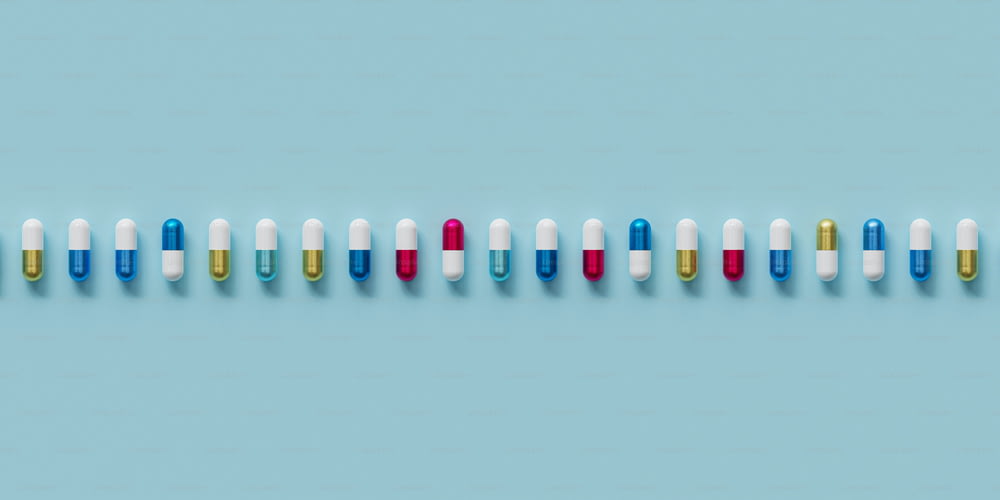 eine Reihe mehrfarbiger Pillen auf blauem Hintergrund