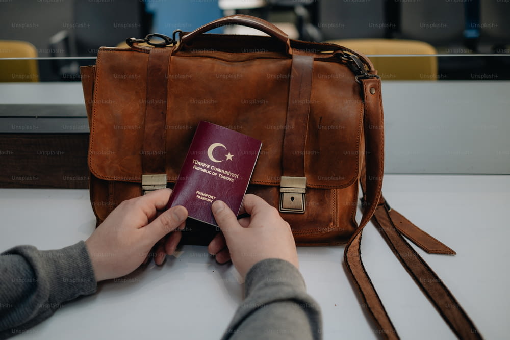 a person holding a passport and a bag