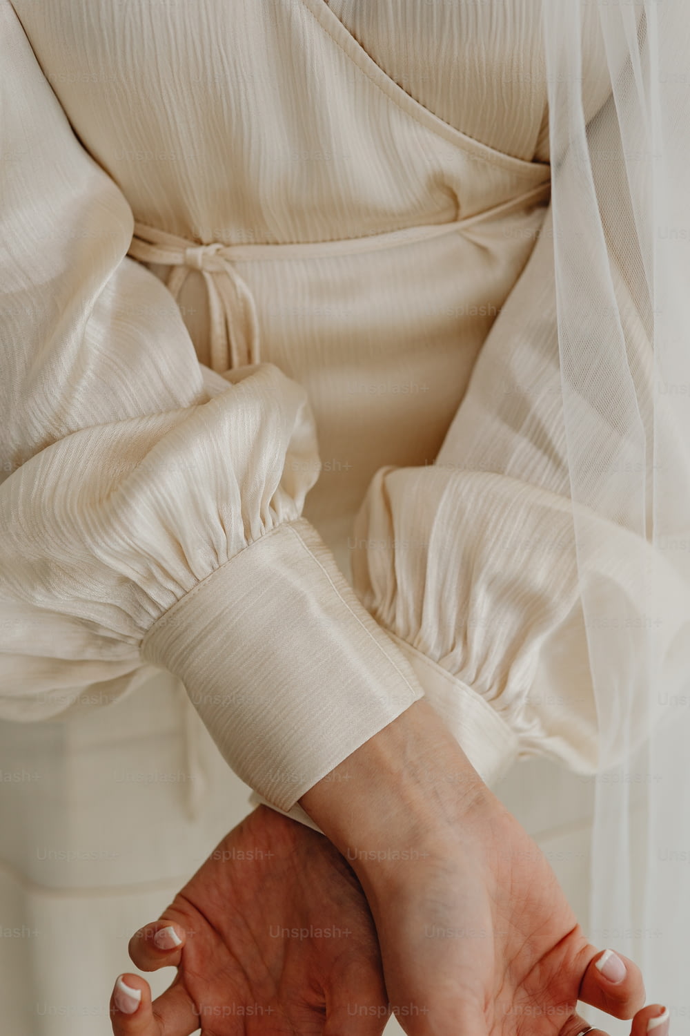 Una mujer con un vestido blanco sosteniendo sus manos juntas