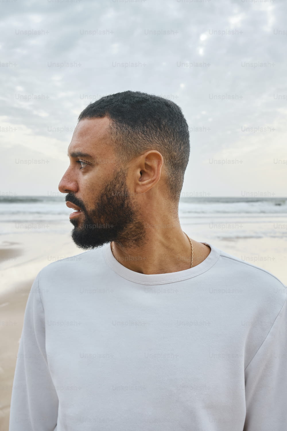 a man with a beard standing on a beach
