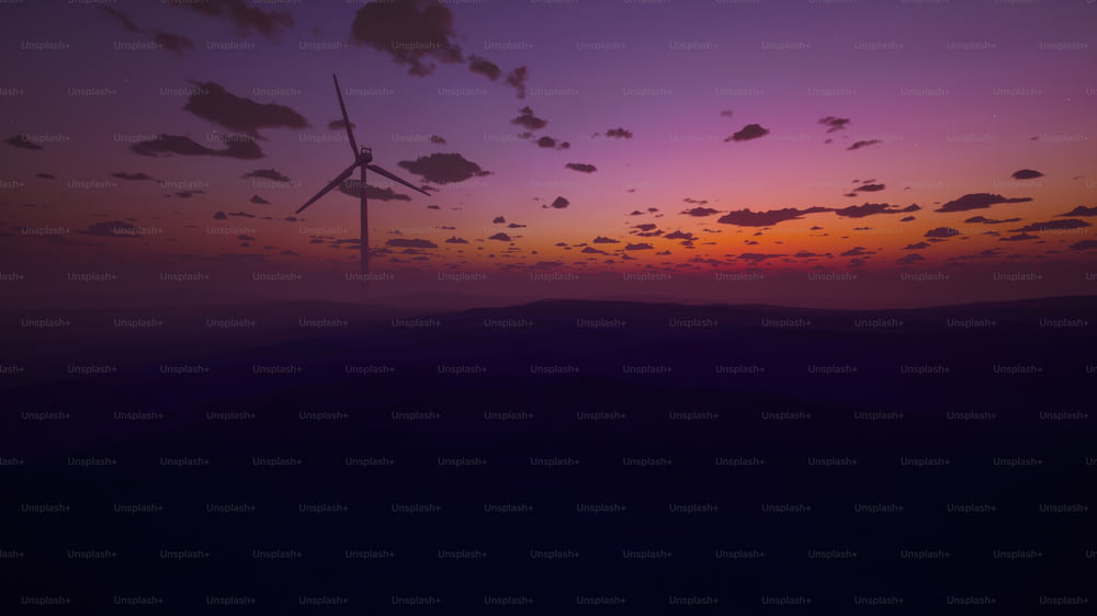 a sunset with a wind turbine in the distance