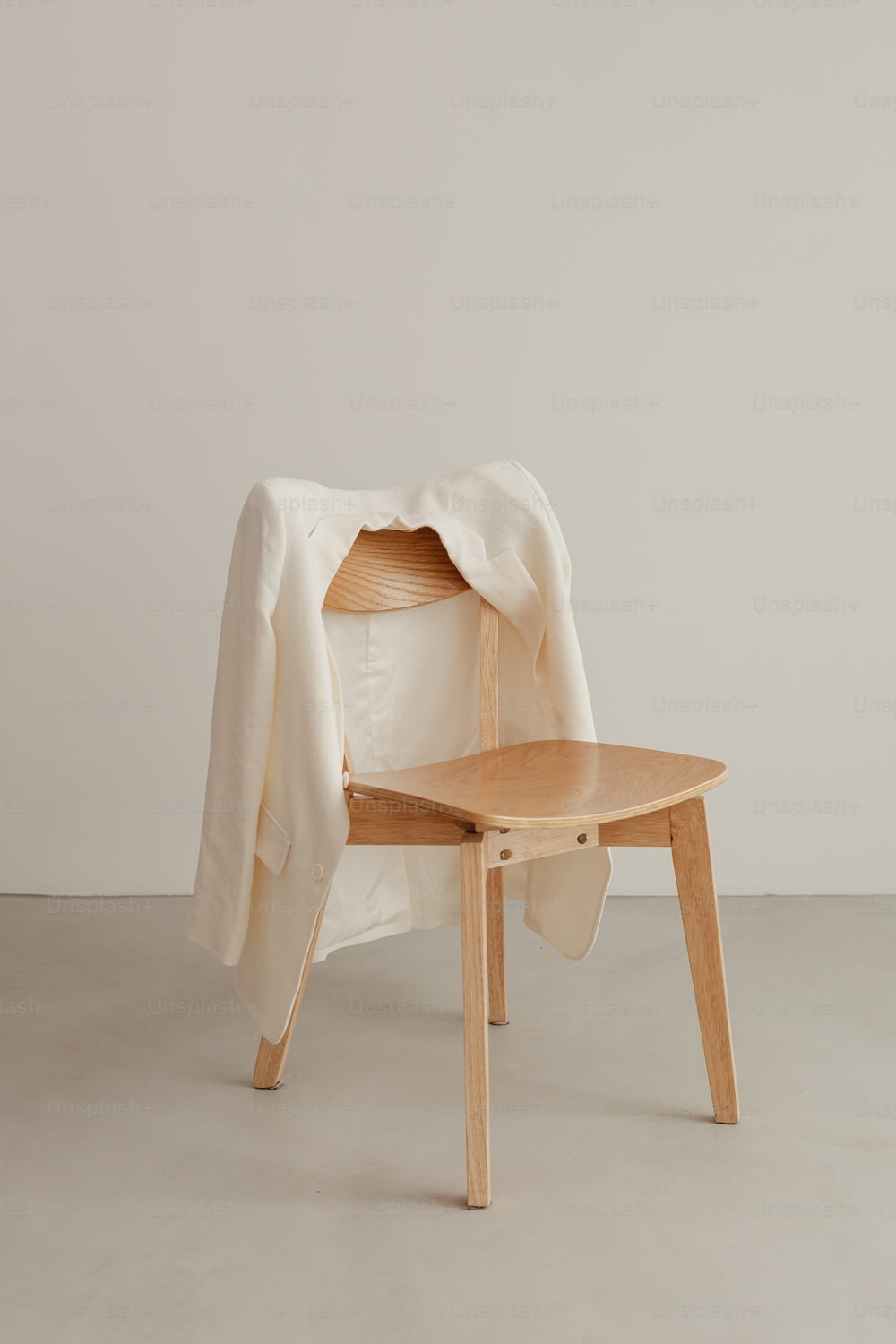 una sedia di legno con una coperta bianca sopra di essa