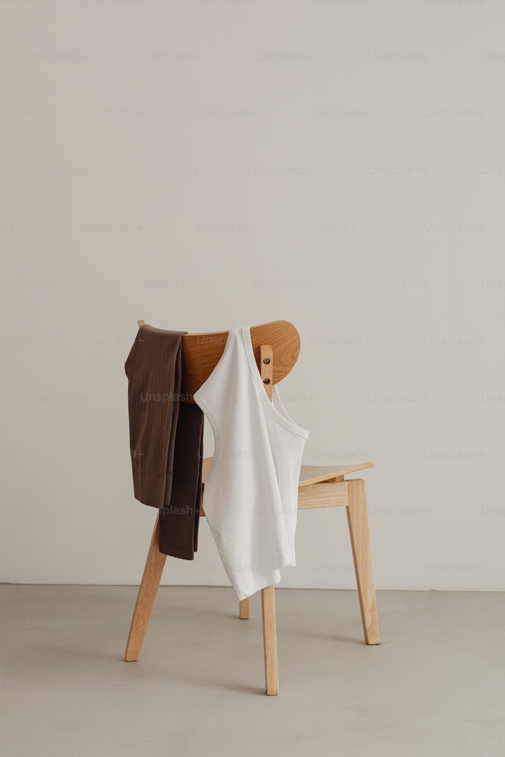 una sedia di legno con una camicia bianca su di essa
