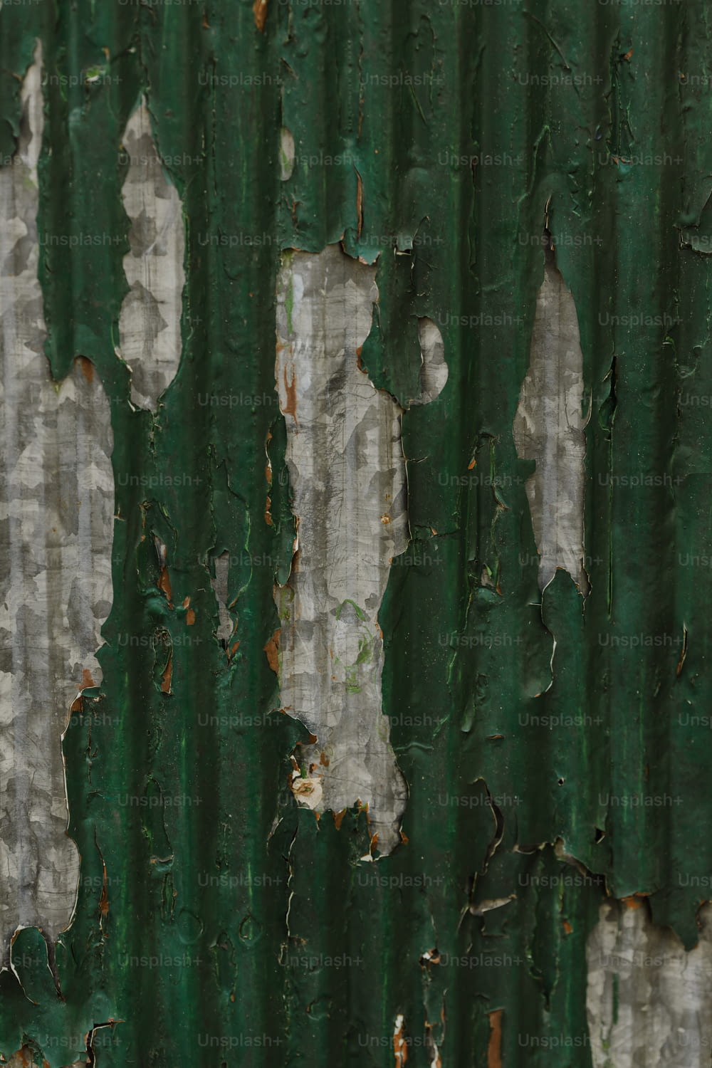 Un primo piano di vernice scrostata su una parete verde