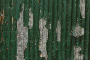 a green and white wall with peeling paint