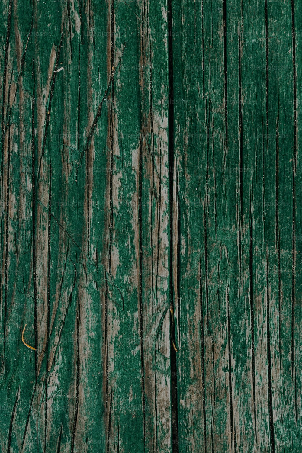 a close up of a green wooden surface