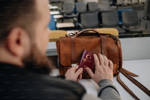 um homem está segurando um passaporte e uma bolsa