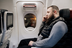 a man sitting on an airplane looking out the window