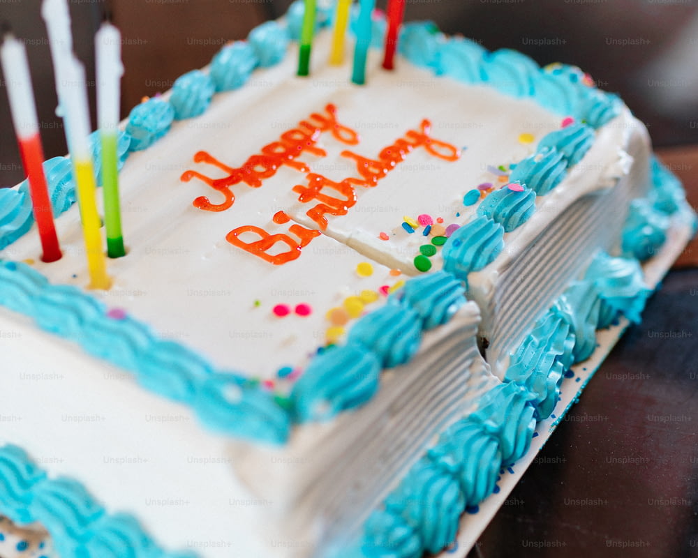 a birthday cake with blue frosting and lit candles
