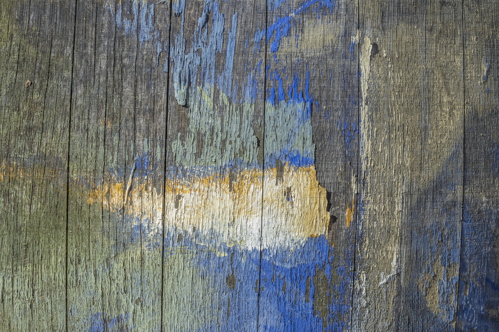 a close up of a wooden surface with blue and yellow paint