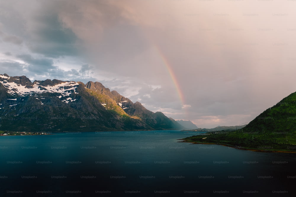 um arco-íris no céu sobre um lago de montanha