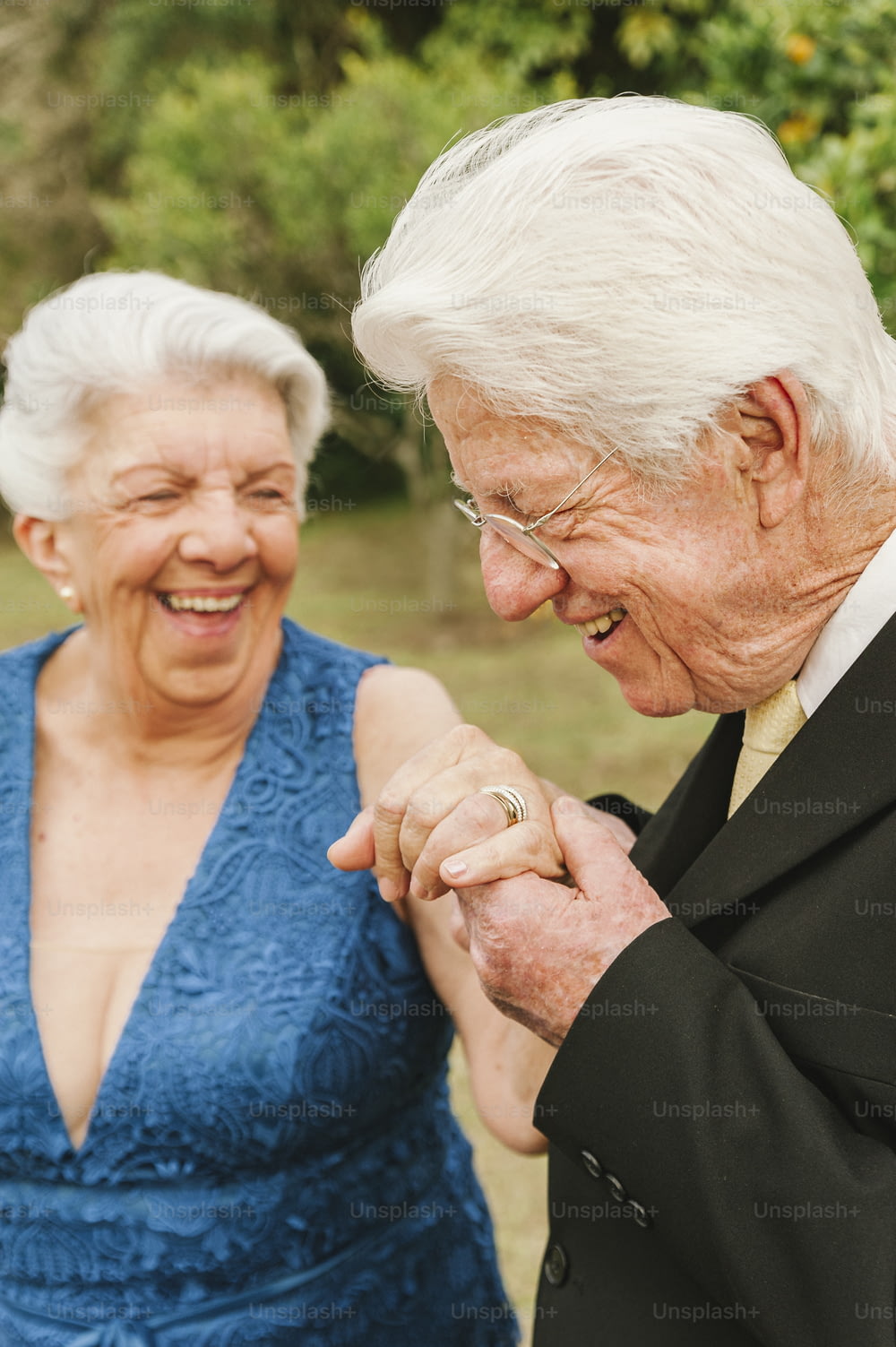 um casal mais velho de mãos dadas e sorrindo
