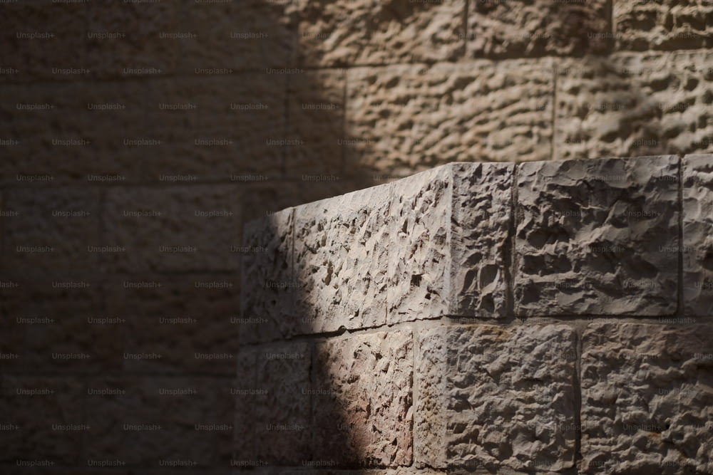 um close up de uma parede de tijolos com uma sombra sobre ele