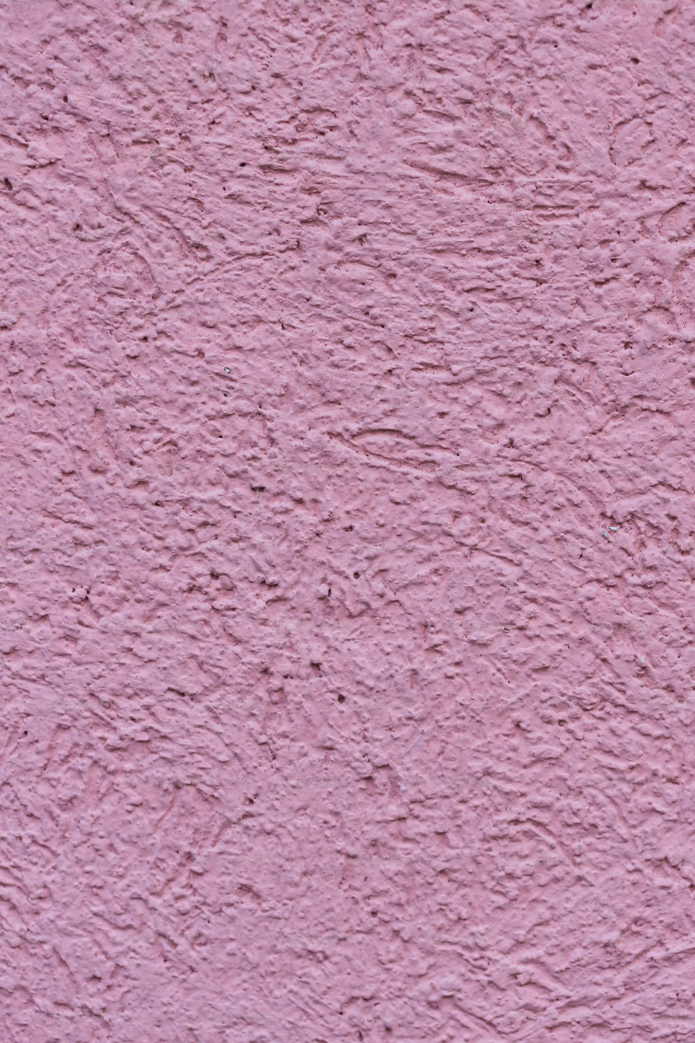 a close up of a pink stucco wall